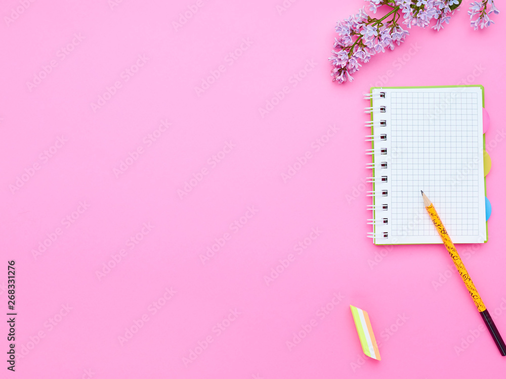 top view of the table of a teenage child, composition of pencil notebook eraser flower on a pink background top view of the table of a teenage child, composition of pencil notebook eraser flower on a pink background