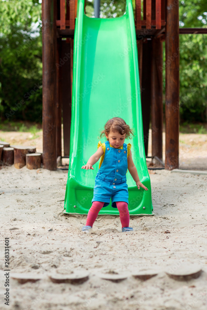 Happy childhood - girl chuting down slide at playground. Happy childhood - girl chuting down slide at playground.