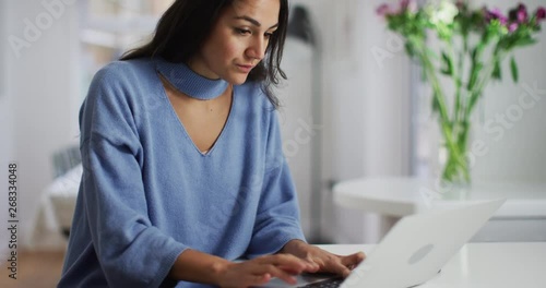 4K Beautiful woman typing on laptop, concentrating & checking her work. Slow motion. photo