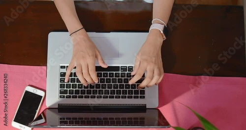 top view From close to wide girl sitting at the computer at the cottage. Girl typing a letter. in slow motion. Shot on Canon 1DX mark2 4K camera