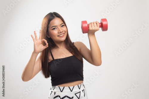 Healthy Asian woman show OK with dumbbells.