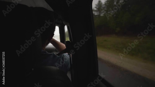 Wallpaper Mural Shot taken from a back seat of a car showing a man the front passenger seat and a foggy / rainy day outside along the road - slow motion. Torontodigital.ca