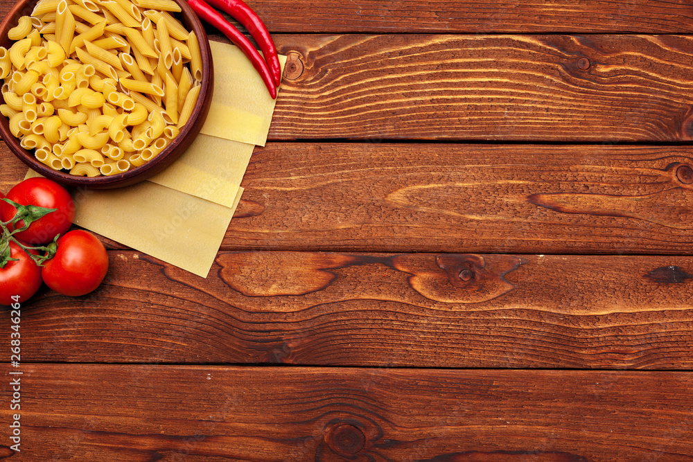 Pasta and ingredients on wooden background with copy space. Top view. Pasta and ingredients on wooden background with copy space. Top view.