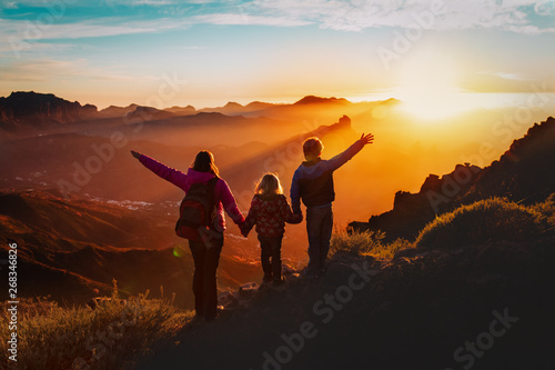Happy mother with kids travel in sunset mountains