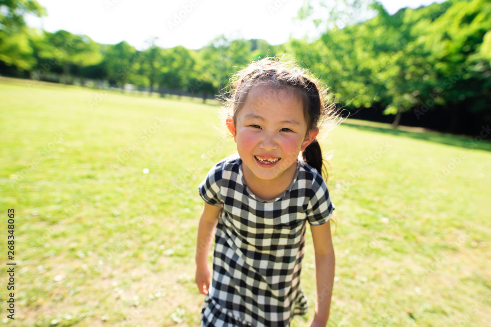 芝生で遊ぶ笑顔の女の子 芝生で遊ぶ笑顔の女の子