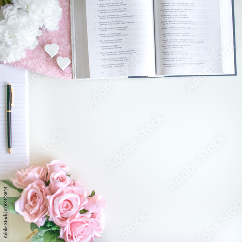lifestyle flat lay with different accessories; flower bouquet, pink roses, open book, Bible, pen, journal, etc. Basel Land, Switzerland - April 12, 2019