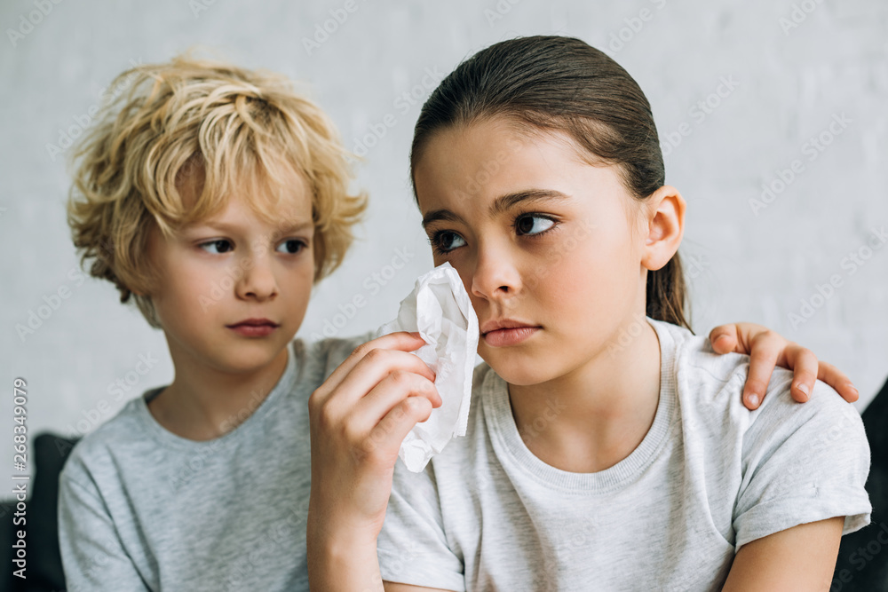 little brother consoling crying sister in living room little brother consoling crying sister in living room