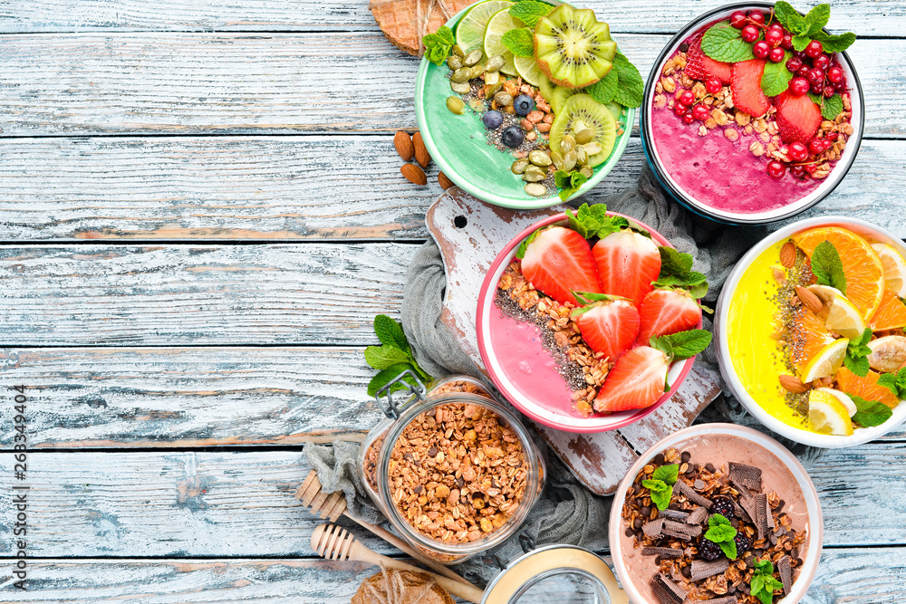 A healthy breakfast. Colorful fruit smoothies with yogurt, fresh fruit and berries. Top view. Free space for your text. On a white background. A healthy breakfast. Colorful fruit smoothies with yogurt, fresh fruit and berries. Top view. Free space for your text. On a white background.