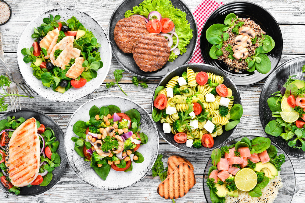 A set of delicious restaurant dishes on a white wooden background Top view. Free space for your text. Flat lay A set of delicious restaurant dishes on a white wooden background Top view. Free space for your text. Flat lay