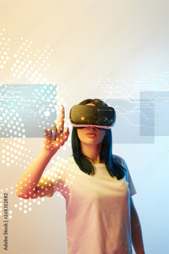 young woman in virtual reality headset pointing with finger at network illustration on beige and blue background young woman in virtual reality headset pointing with finger at network illustration on beige and blue background