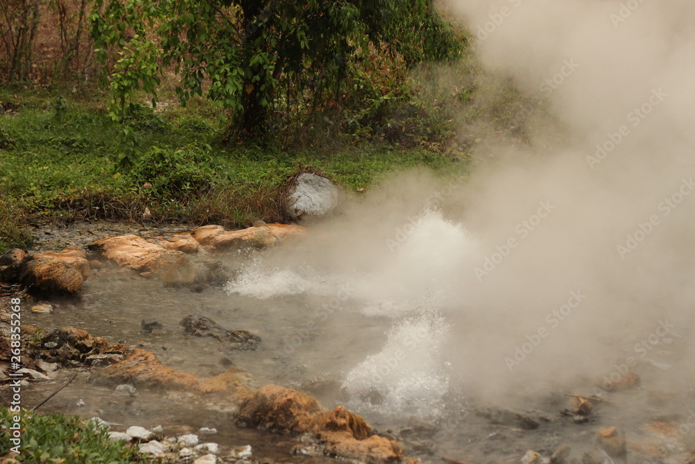steam rising and rolling from the bubbling boiling water of a volcanic hot spring in a beautiful national park near Pai, Northern Thailand, Southeast Asia