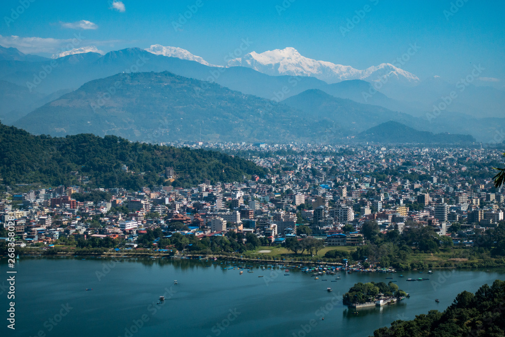 Pokhara city with turquoise lake and himalayas mountains in background