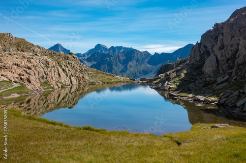 Mountain lake with reflections and grass in the Pyrenees grassMountain lake with reflections and grass in the Pyrenees, France and Spain Border