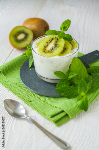 Homemade proteic greek yogurt with kiwi, lemon and mint and healthy shack of kiwi, banana and lemon photo