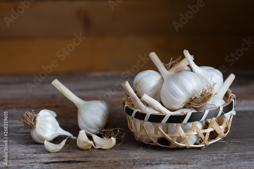 garlic on wooden cup on wood table.