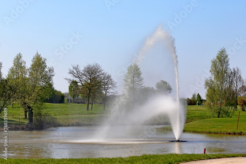 Water fountain on pond, on meadow