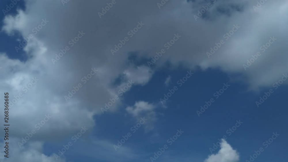 Time lapse, motion fluffy white clouds moving on blue sky background Time lapse, motion fluffy white clouds moving on blue sky background