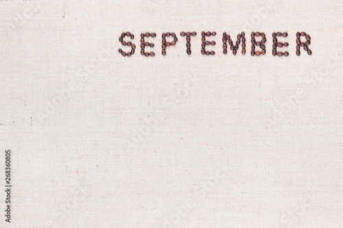 The word September written with coffee beans shot from above, aligned at the top right.