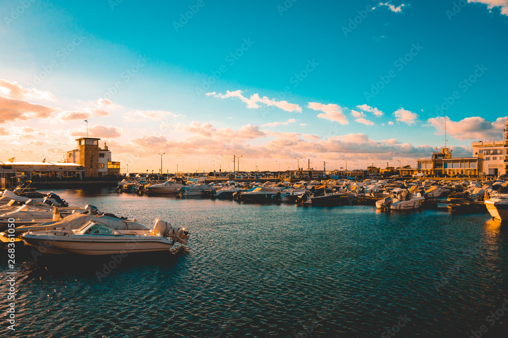 colorful picture of harbor at faro with darken blue in the sky and water