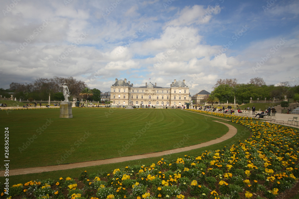 Obraz premium Relaxation on cloudy sky in the summer at green beautiful field public park in Paris, luxembourg garden, France, travel destination backgrounds, 