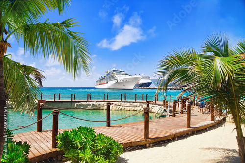 Fototapeta Naklejka Na Ścianę i Meble -  View from beach at tropical resort on cruise ships docked at port 