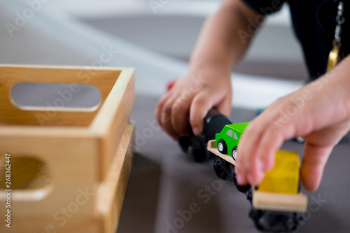 Young cute kid playing wooden toy on table at home