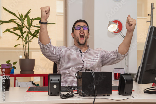 businessman, in the office, with gesture of joy, exaltation photo
