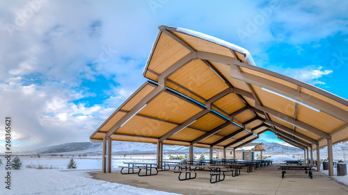Clear Panorama Tables and benches inside a pavilion surrounded by a frosty ground in winter