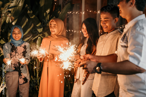 happiness lighting the takbir night fireworks with friends while celebrating the Eid holiday photo