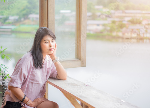 Beautiful Asian Woman. feeling enjoy relaxed. Thinking something. Sitting on chair and table near the window..Casual wearing pink shirt. With atmosphere Lagoon. sunlight of the morning. Free Download Beautiful Asian Woman. feeling enjoy relaxed. Thinking something. Sitting on chair and table near the window..Casual wearing pink shirt. With atmosphere Lagoon. sunlight of the morning. - GFXLoad