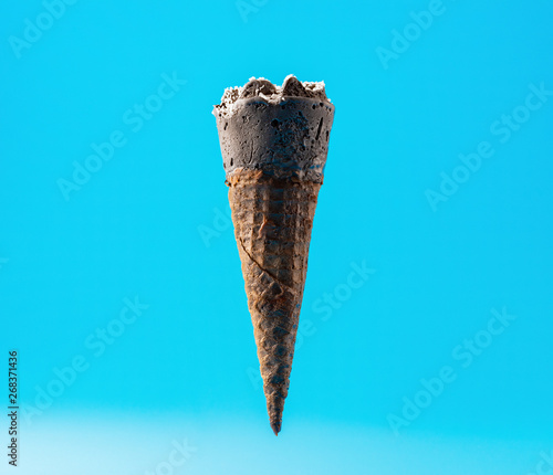 black color ice cream cone with shredded coconut on blue background