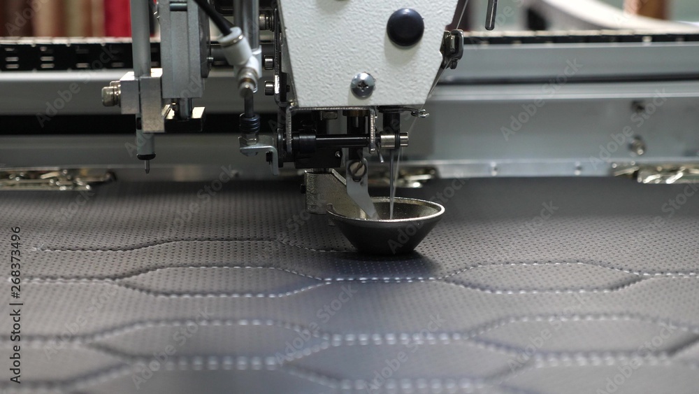 Foto de Robot sewing machine. automatic sewing machine. Robotics works