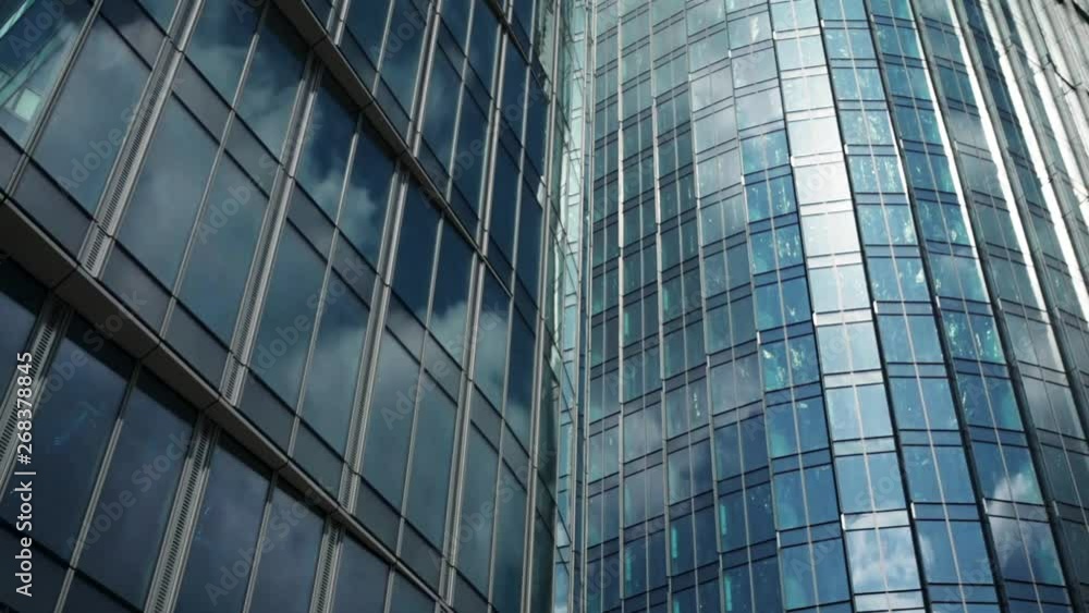 Time lapse of clouds reflecting onto the glass of a large office building. Modern Business Office Buildings with Glass Reflection. Reflection of clouds in a modern skyscraper. Time lapse of clouds reflecting onto the glass of a large office building. Modern Business Office Buildings with Glass Reflection. Reflection of clouds in a modern skyscraper.
