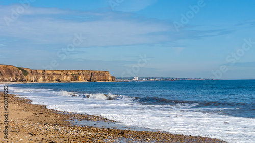A golden coastline at Seaham Beach in the North East of England. Image showing cliff faced coastline, golden sands and calm north sea to the right.