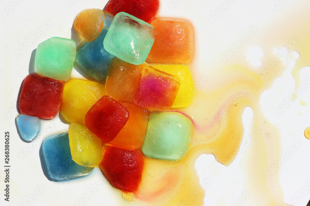 Bright, colored cubes of frozen juice melt. Bright, colored cubes of frozen juice melt.