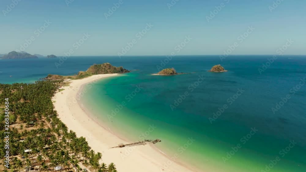 Aerial view of tropical island with sandy beach. Nacpan, El Nido, Palawan, Philippines. Seascapewith sea, sand, palm trees. Summer and travel vacation concept Aerial view of tropical island with sandy beach. Nacpan, El Nido, Palawan, Philippines. Seascapewith sea, sand, palm trees. Summer and travel vacation concept