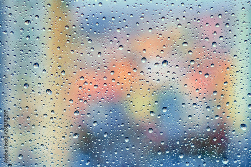 Raindrops on the window glass with blurry city background