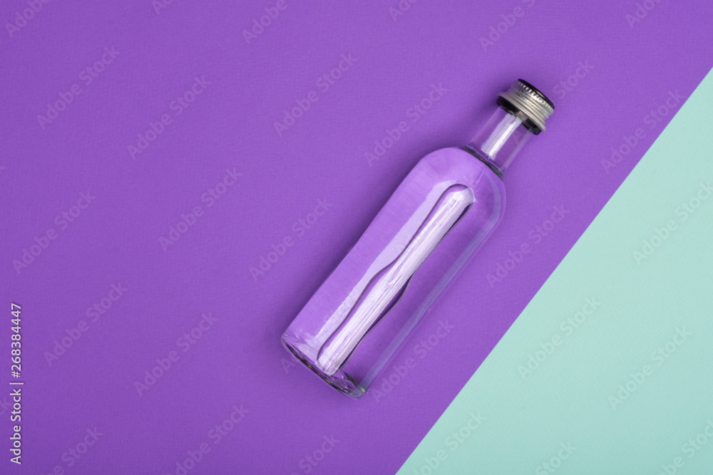 bottle with water on bright purple and azure background bottle with water on bright purple and azure background
