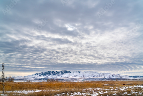 Dramatic sky filled with cottony clouds over a scenic landscape in winter