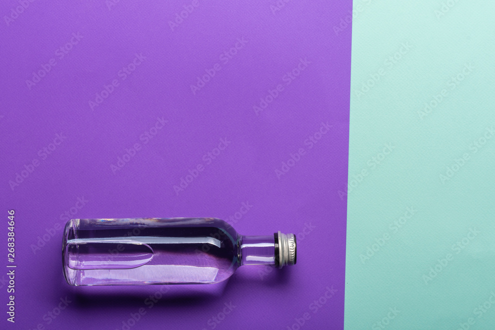 bottle with water on bright purple and azure background bottle with water on bright purple and azure background