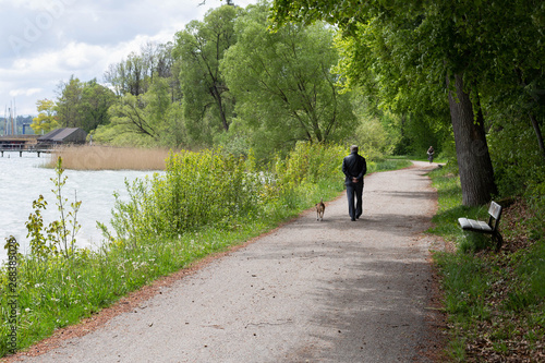 Spaziergänger mit Hund am Starnberger See