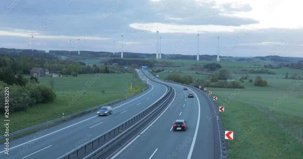 highway traffic with wind turbines on a horizon highway traffic with wind turbines on a horizon