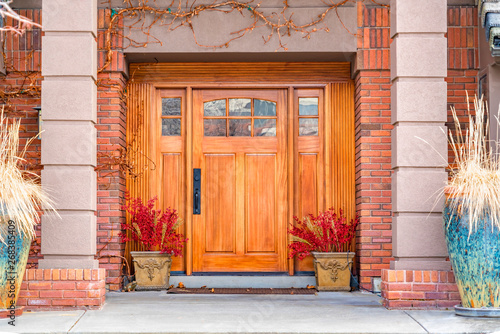 Brown wooden front door with decorative glass panels at the entrance of a home