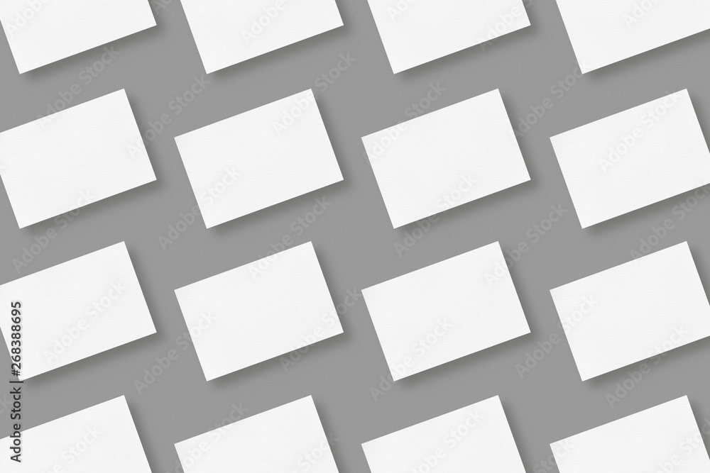 White blank horizontal business cards arranged in rows on gray solid color background, geometric business card mockup with copy space White blank horizontal business cards arranged in rows on gray solid color background, geometric business card mockup with copy space