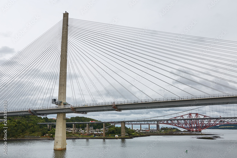 The new Queensferry Crossing bridge over the Firth of Forth with the older Forth Road bridge and the iconic Forth Rail Bridge in Edinburgh Scotland. The new Queensferry Crossing bridge over the Firth of Forth with the older Forth Road bridge and the iconic Forth Rail Bridge in Edinburgh Scotland.