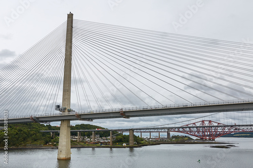 The new Queensferry Crossing bridge over the Firth of Forth with the older Forth Road bridge and the iconic Forth Rail Bridge in Edinburgh Scotland.
