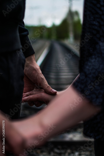 the couple holding hands at the railway