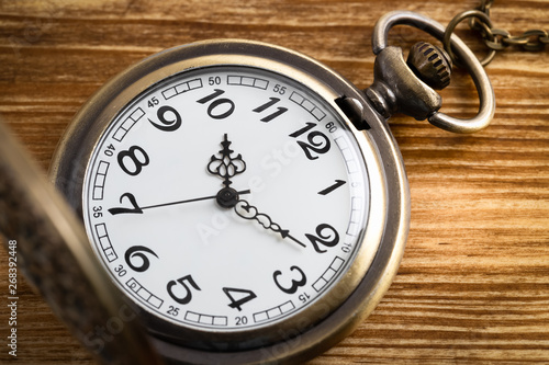 Vintage pocket watch clock on wooden background