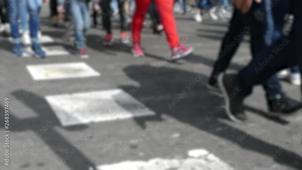 Front view blurry pedestrians walking.Slow motion. Detail of legs crossing a street in the city of Barcelona. Front view blurry pedestrians walking.Slow motion. Detail of legs crossing a street in the city of Barcelona.