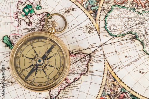 Compass on vintage ancient map, concept for direction transportation and travel